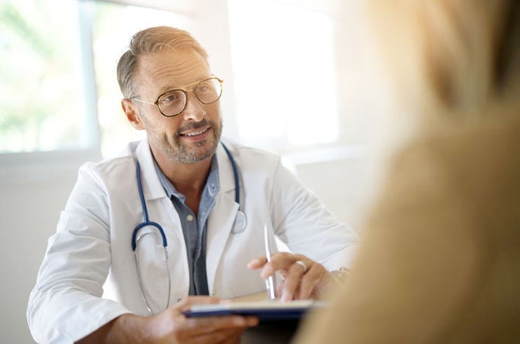 male detox doctor talking to patient at his desk