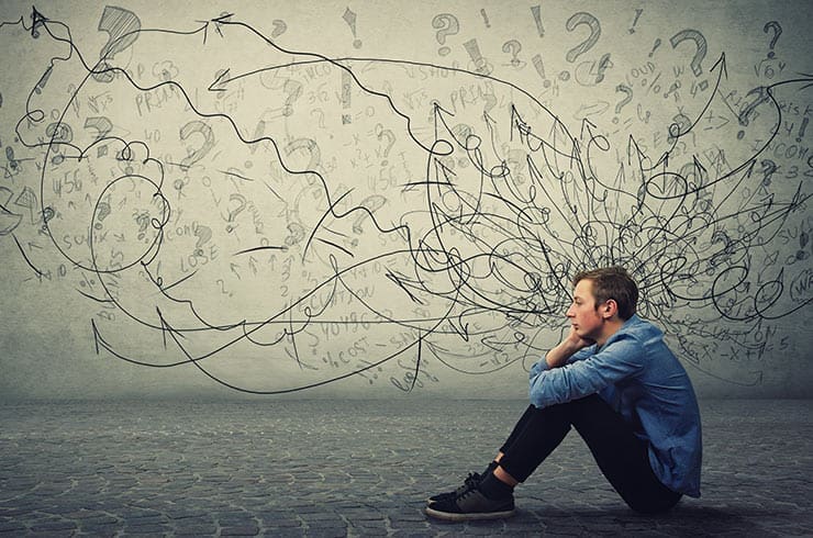 man sits on the floor with illustration behind him representing an anxiety diagnosis