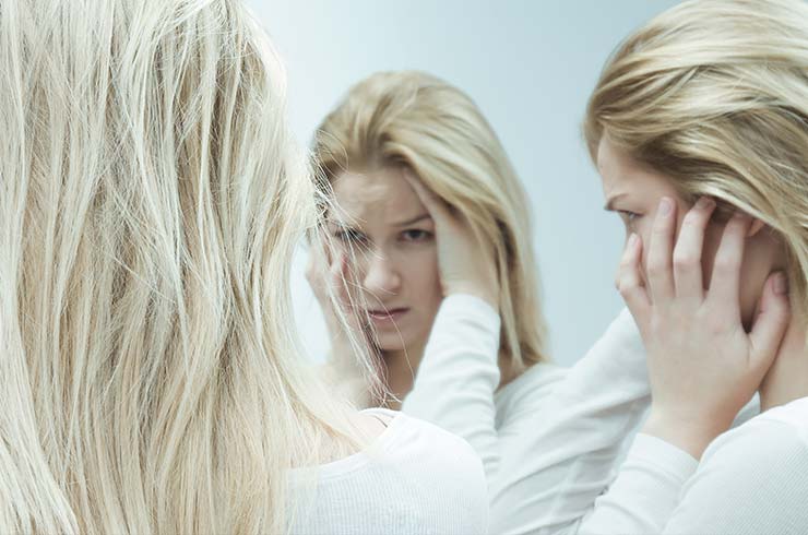 woman with three versions of herself showing signs of schizophrenia