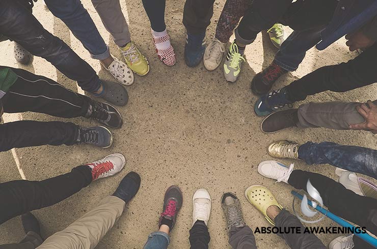 group of people put their feet in a circle to support each other's addiction recovery