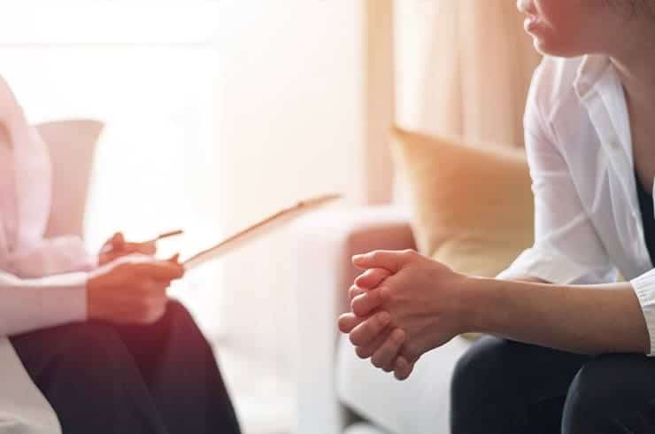 woman sitting with female doctor discussing the first step toward treating alcoholism