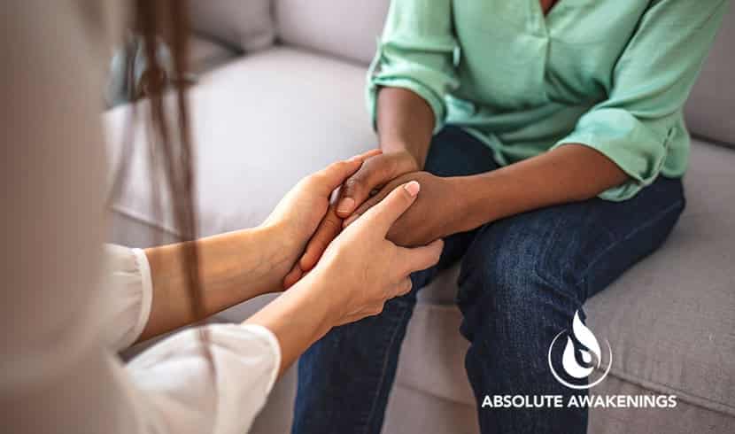 two women sitting with each other holding handing to show forgiveness