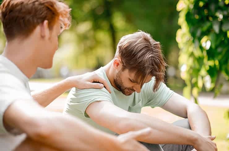 man supports another man with PTSD outside
