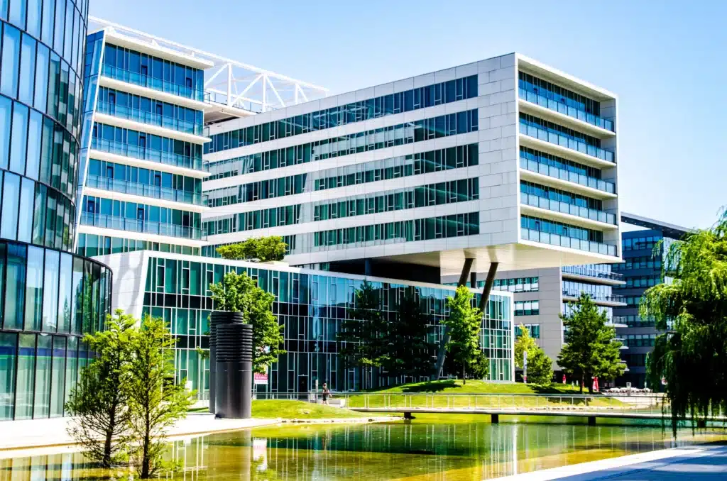 Modern medical center campus with glass buildings and reflection pond