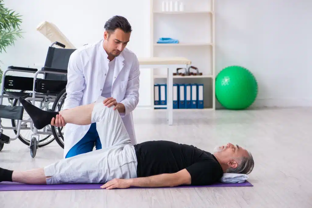 Physiotherapist stretching the patient’s leg during rehabilitation therapy